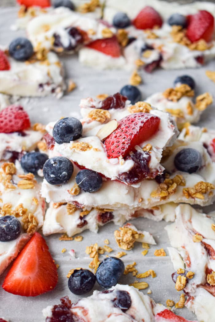 Frozen yogurt bark topped with strawberries, blueberries, and granola.