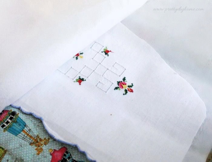 Ironing interfacing onto a vintage embroidered pillowcase between sheets of parchment paper.