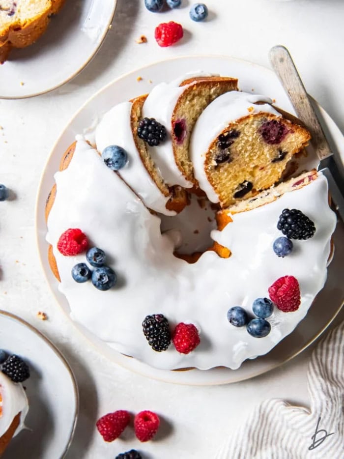 Mixed berry pound cake topped with white glaze and fresh berries.
