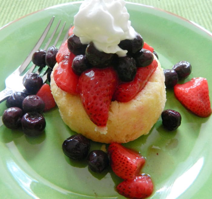 No bake berry mini cake topped with strawberries, blueberries, and whipped cream.