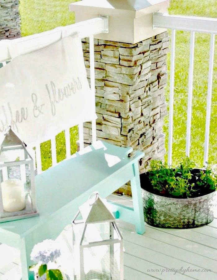 Porch bench decorating idea with a painted bench, soft cushion back, and simple outdoor decor on a bright front porch.