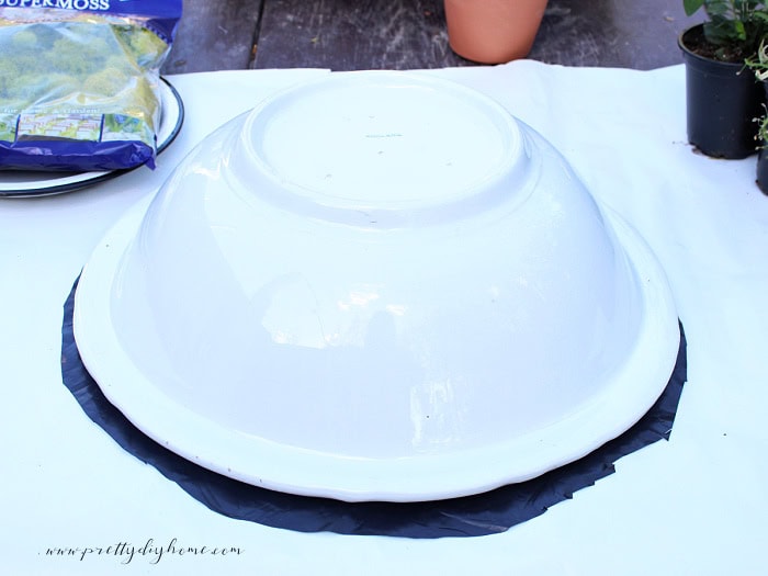 Tracing and cutting plastic to fit inside a vintage porcelain wash basin for a container herb garden.