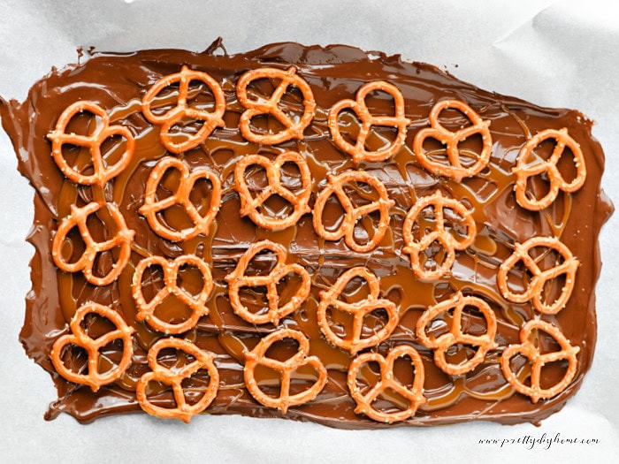 Pretzels added to melted chocolate while making caramel apple bark.