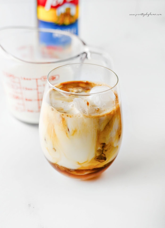 Caramel apple latte with milk and espresso swirling together.