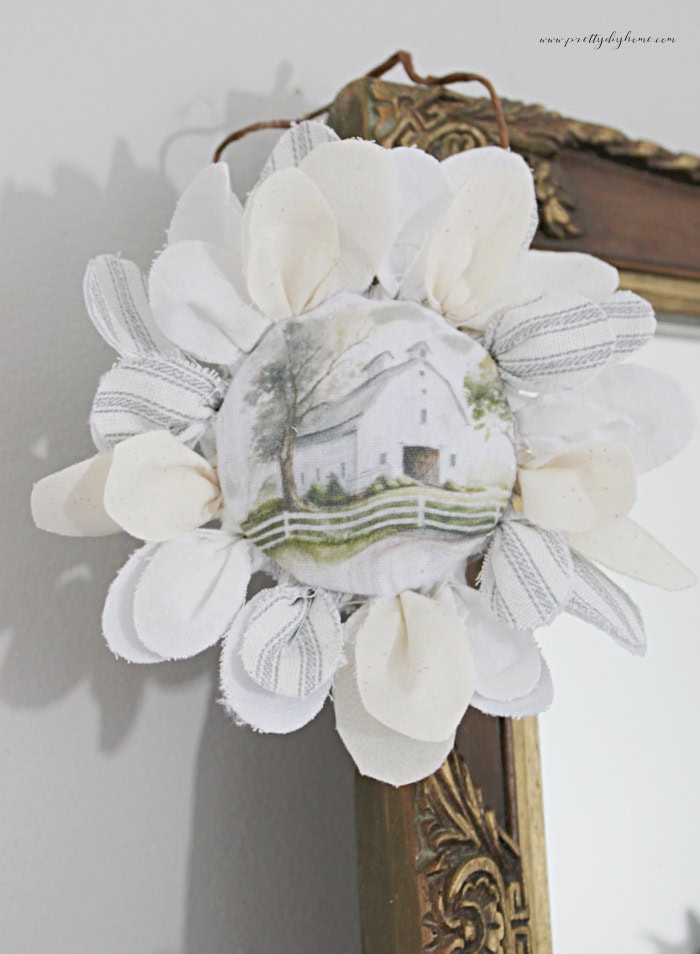 Completed barn fabric flower with a vintage barn center and lace-trimmed fabric petals.