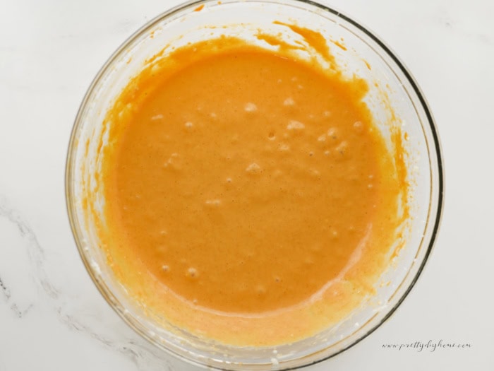 Pumpkin cream cheese filling mixed until smooth in a glass mixing bowl, ready to swirl into pumpkin brownie batter.