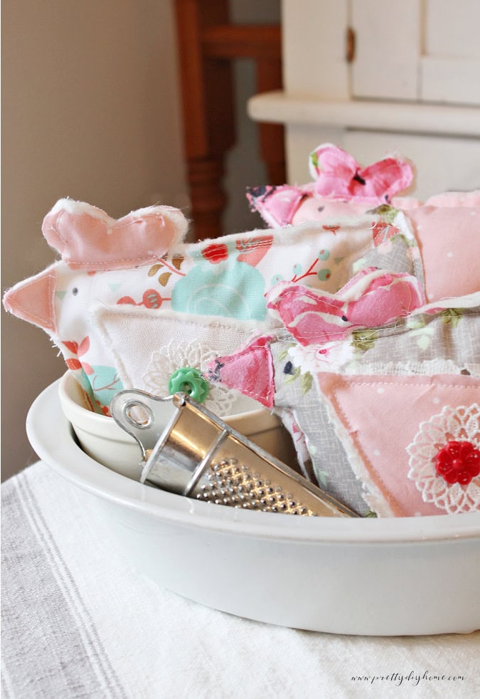 DIY fabric chickens displayed in an ironstone bowl with a striped tea towel and vintage kitchen accessories, creating charming farmhouse bowl stuffers made from scrap fabric.