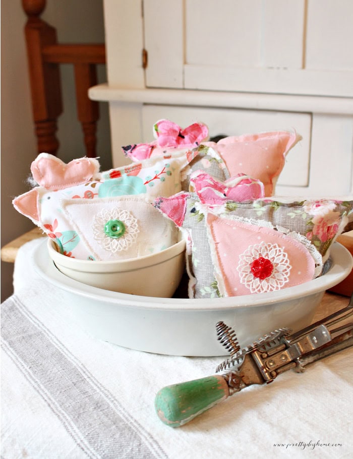 DIY fabric chicken bowl stuffers displayed in a vintage ironstone bowl with a grainsack striped tea towel, creating a cheerful farmhouse decor display.