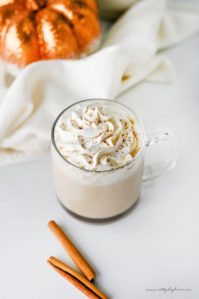 Easy pumpkin chai latte topped with whipped cream and pumpkin pie spice.