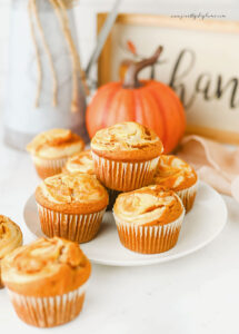 Easy pumpkin cheesecake muffins with cream cheese swirl on a white plate.