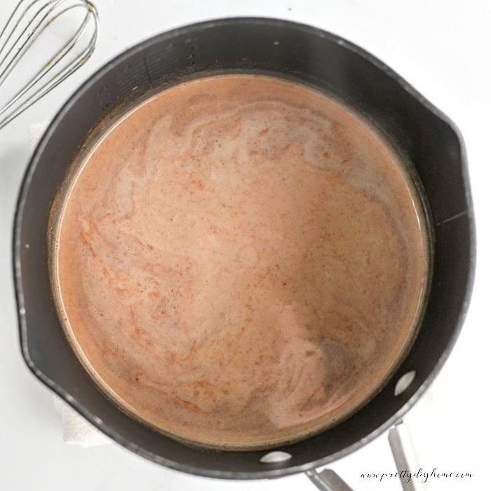 Pumpkin chai latte warming in a saucepan before serving.