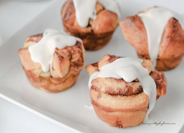 Homemade cinnamon roll muffins baked until golden brown and topped with icing.