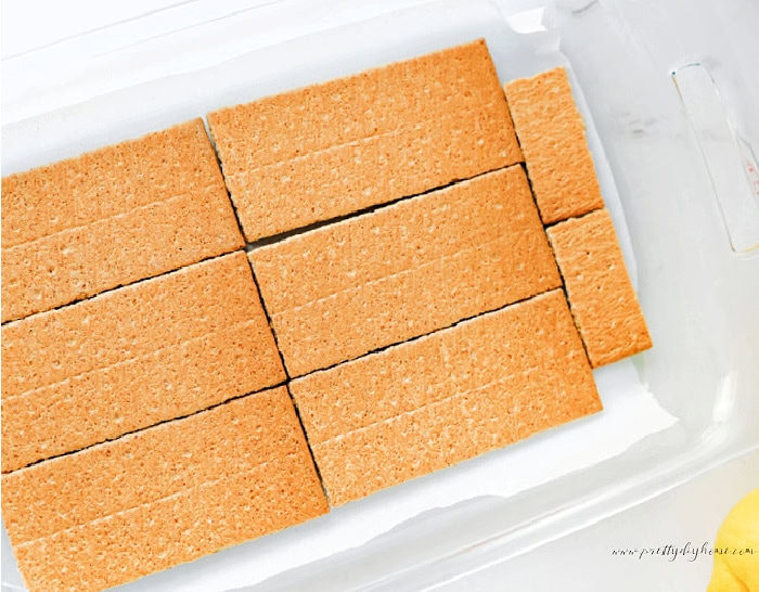 First layer of graham crackers arranged in a baking dish for lemon icebox cake