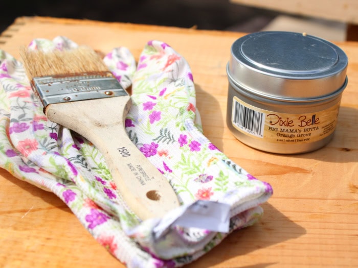 Supplies used to restore old wooden boxes including Big Mama's Butta wood conditioner, gloves, and a chip brush.