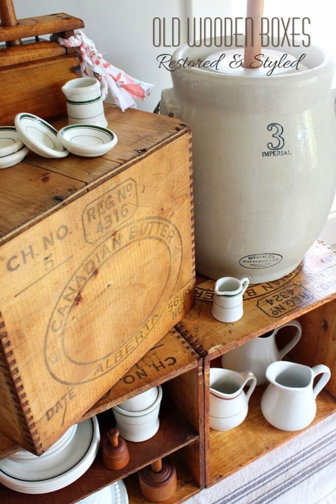 Restored old wooden boxes styled with vintage creamery antiques, ironstone pitchers, and farmhouse decor.
