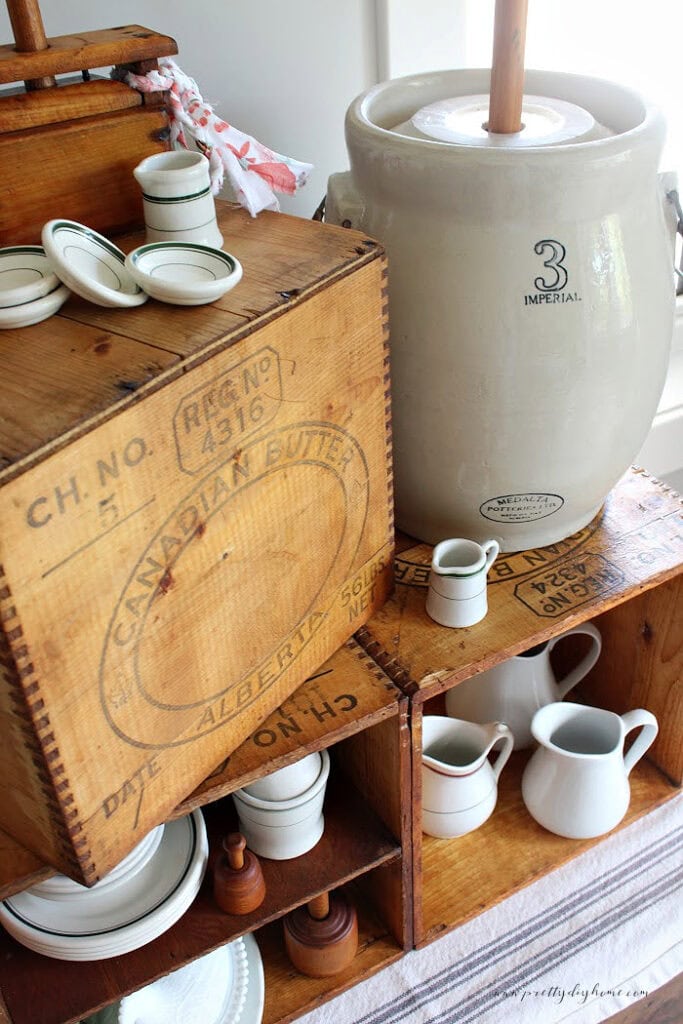 Old wooden butter box with original manufacturer's markings displayed with a Medalta butter churn and vintage creamery antiques.