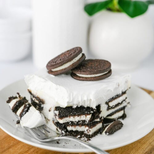 Slice of Oreo Icebox Cake showing layers of Oreo cookies and cream filling.
