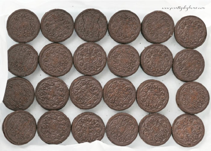 Single layer of Oreo cookies arranged in a parchment-lined baking dish.