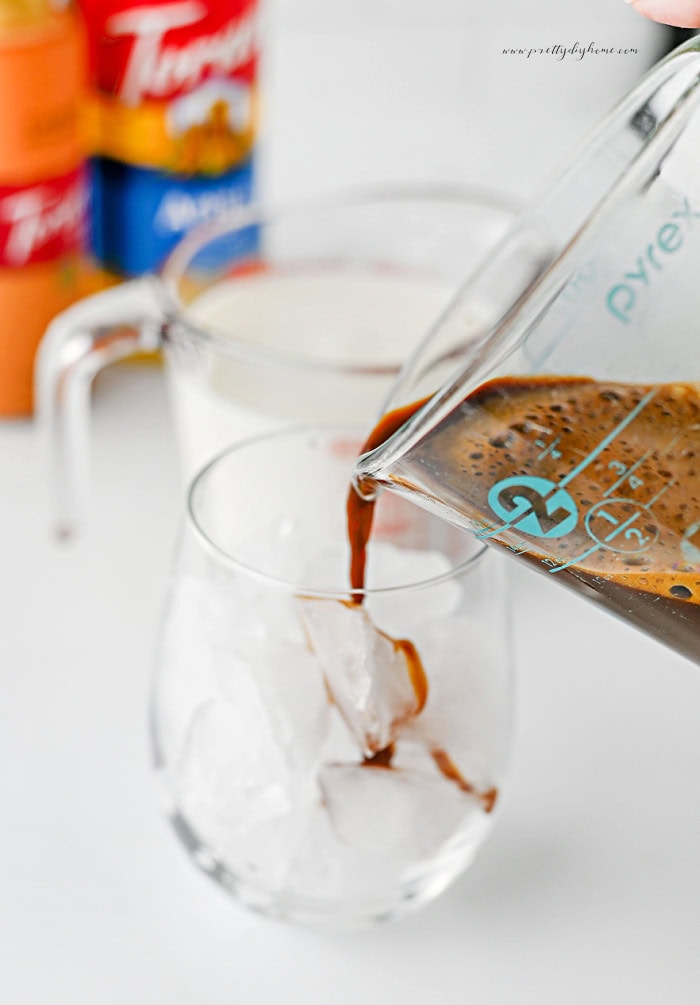 Pouring espresso over ice for a caramel apple latte.