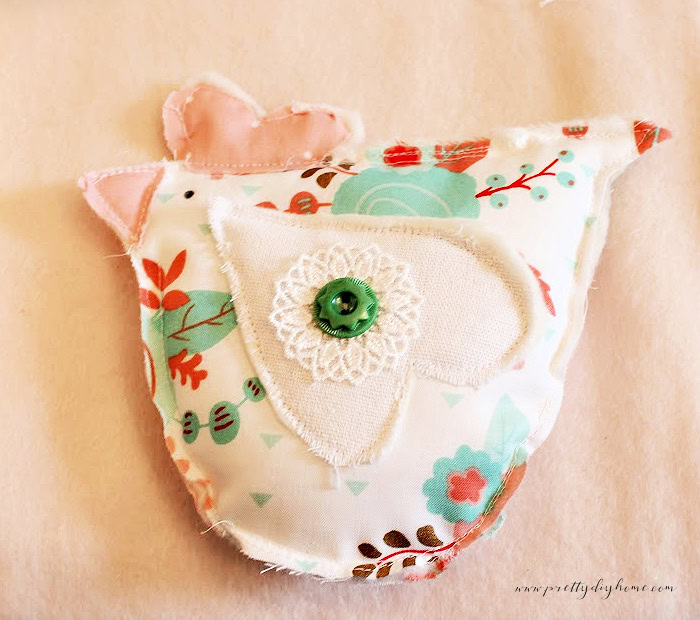 Finished fabric chicken bowl filler with a fabric comb, beak, decorated wing, and simple hand-drawn eye.