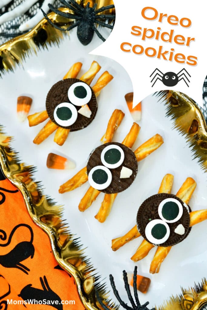 hree Oreo spider cookies with pretzel legs, oversized candy eyes, and candy corn fangs are arranged on a white plate beside the words “Oreo Spider Cookies.”