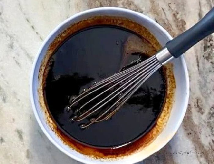 Warm molasses and melted butter whisked together for gingerbread muffin batter.