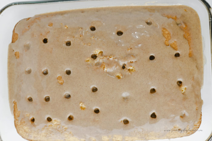 Warm cinnamon brown sugar filling spread over a freshly baked poke cake, soaking into the holes and creating a rich cinnamon swirl throughout the cake.