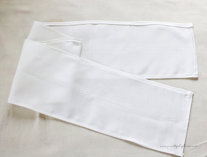 Finished damask ruffle strips showing the narrow sewn hems and neatly finished corners.
