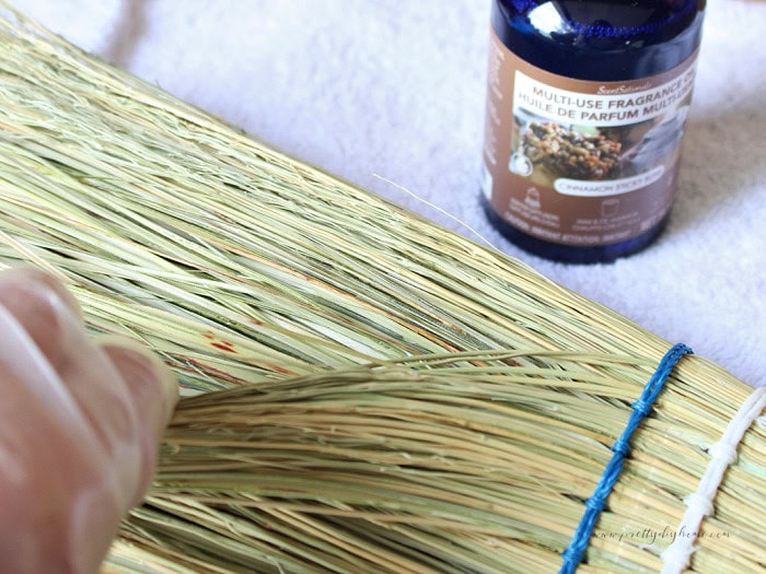 Adding cinnamon fragrance oil between the natural broomcorn fibres to make a DIY cinnamon broom.