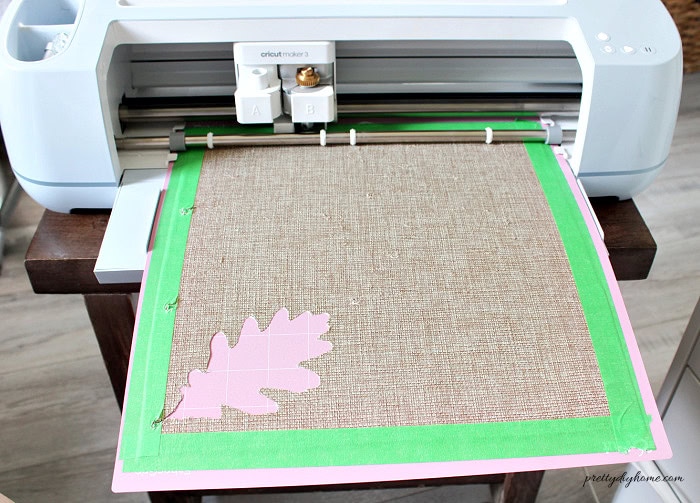 Checking the coarse linen cut by removing one oak leaf with a weeding tool before unloading the Cricut mat.