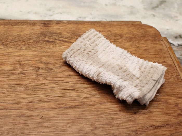 Cleaning a vintage wood tray with a damp cloth before a fall makeover.