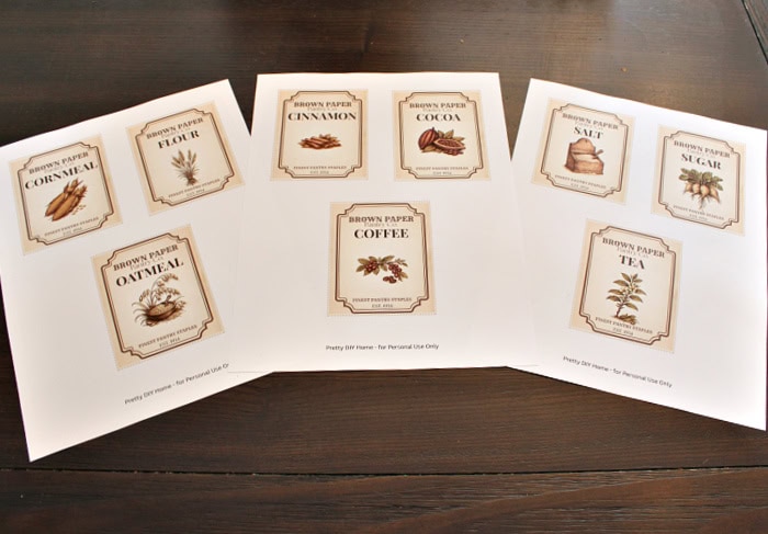 Nine free printable vintage pantry labels are printed on three sheets of paper for flour, cornmeal, oatmeal, cinnamon, cocoa, coffee, salt, sugar, and tea.