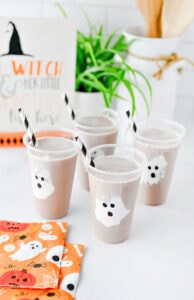 Halloween ghost chocolate milk drinks for kids with marshmallow fluff ghosts in clear cups.