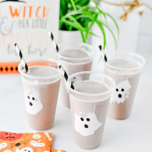 Halloween ghost chocolate milk drinks for kids with marshmallow fluff ghosts in clear cups.