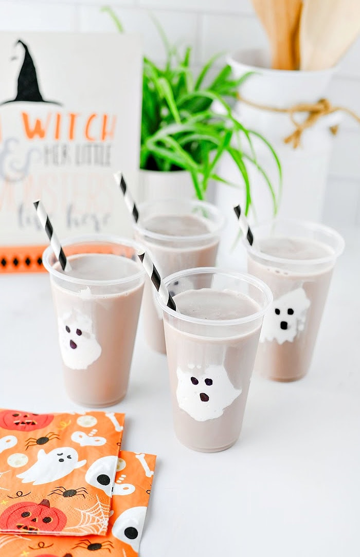 Halloween ghost chocolate milk drinks for kids with marshmallow fluff ghosts in clear cups.