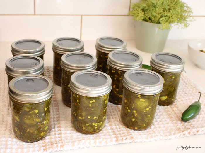 Homemade cowboy candy jalapeños canned in small jam jars.