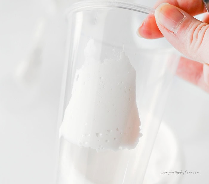 Marshmallow fluff being spread inside a clear cup to make a ghost shape for chocolate milk.