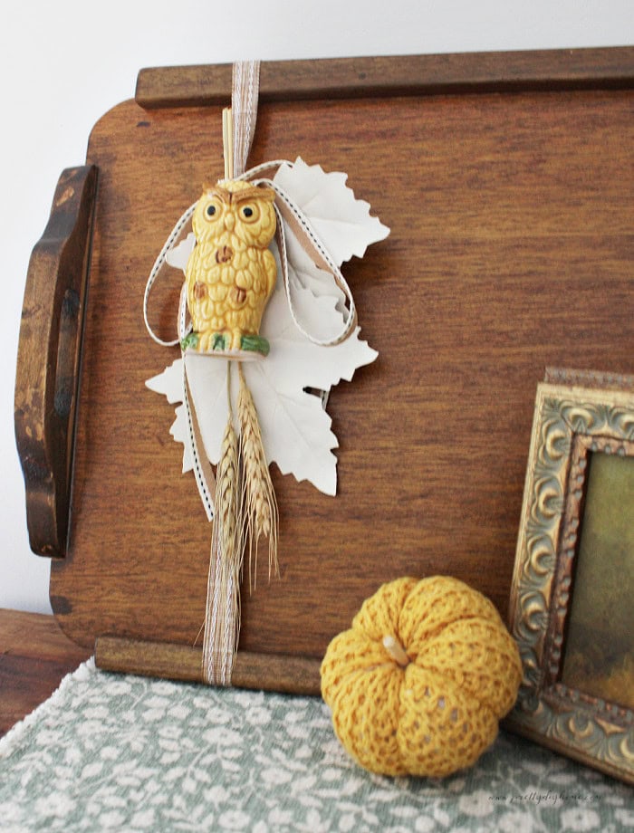 Vintage owl salt shaker attached to a wood tray with cream leaves and ribbon for fall decor.