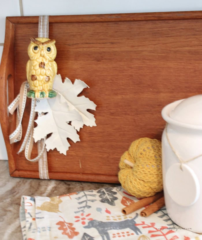 Vintage wood tray styled with a vintage owl, cream leaves, pumpkin, and white canister for fall kitchen decor.