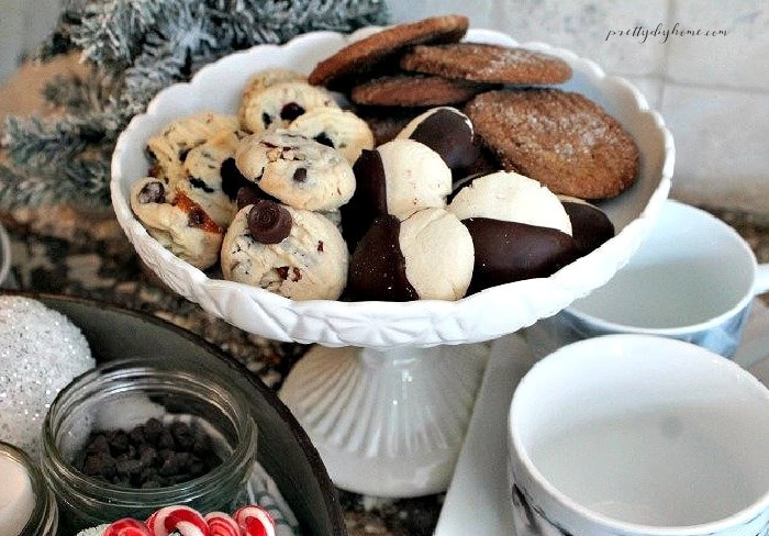 Christmas hot chocolate bar with cookies, chocolate treats, and mugs.