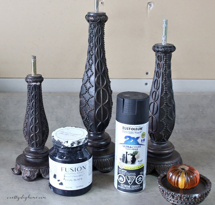 Dismantled Halloween candlesticks with black paint options and the orange center section removed before painting.