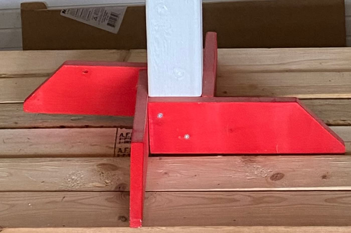 Closeup of four wood base pieces screwed around a 4x4 post for a DIY outdoor Halloween sign.