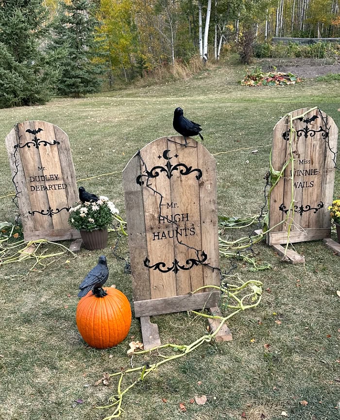 DIY pallet Halloween gravestones with pumpkins, crows and rustic outdoor decorations.