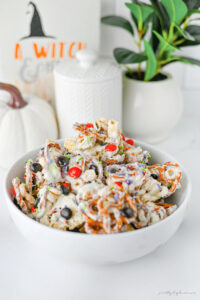 Ghost Crunch easy Halloween party snack mix with white chocolate cereal, pretzels, Halloween M&Ms, and colorful sprinkles.