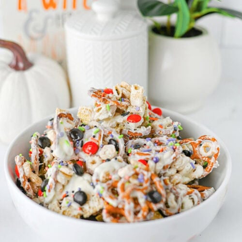 Ghost Crunch easy Halloween party snack mix with white chocolate cereal, pretzels, Halloween M&Ms, and colorful sprinkles.