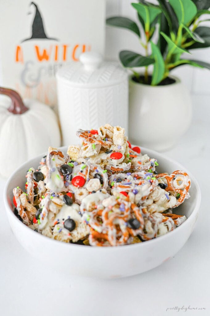 Ghost Crunch easy Halloween party snack mix with white chocolate cereal, pretzels, Halloween M&Ms, and colorful sprinkles.