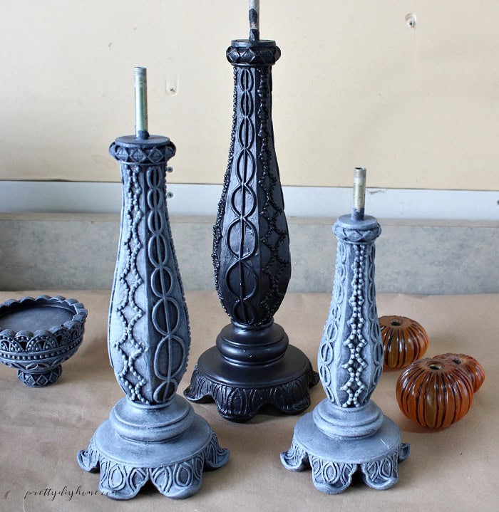 Three Halloween candlesticks showing black paint, lightly waxed details, and a fuller ghostly white wax finish.
