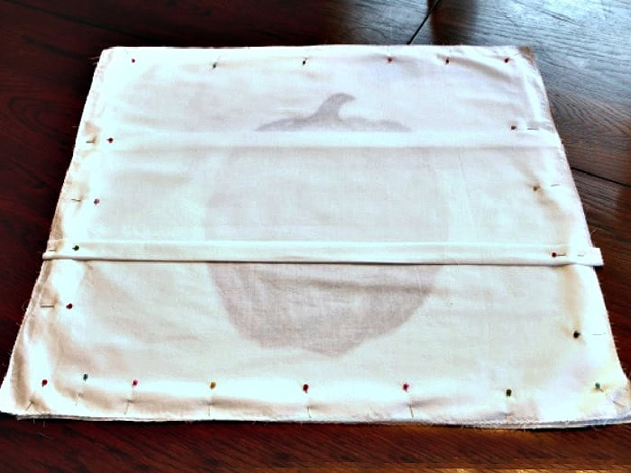 Pinned back pieces of an envelope pillow cover ready for sewing.