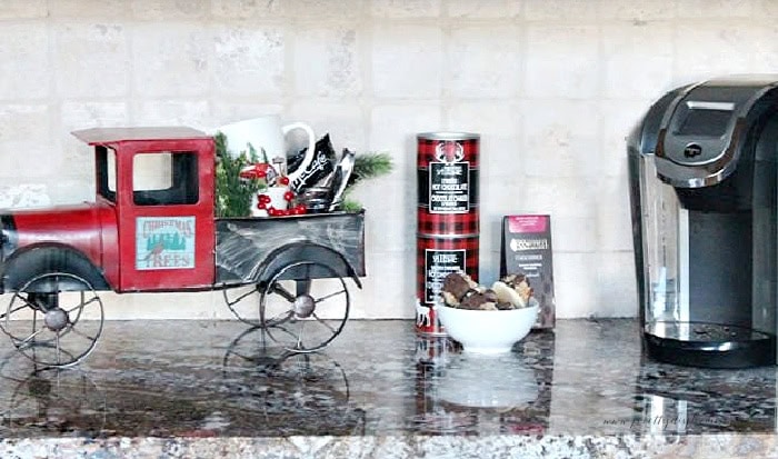 Small Christmas coffee and hot chocolate bar with a red truck and Keurig.