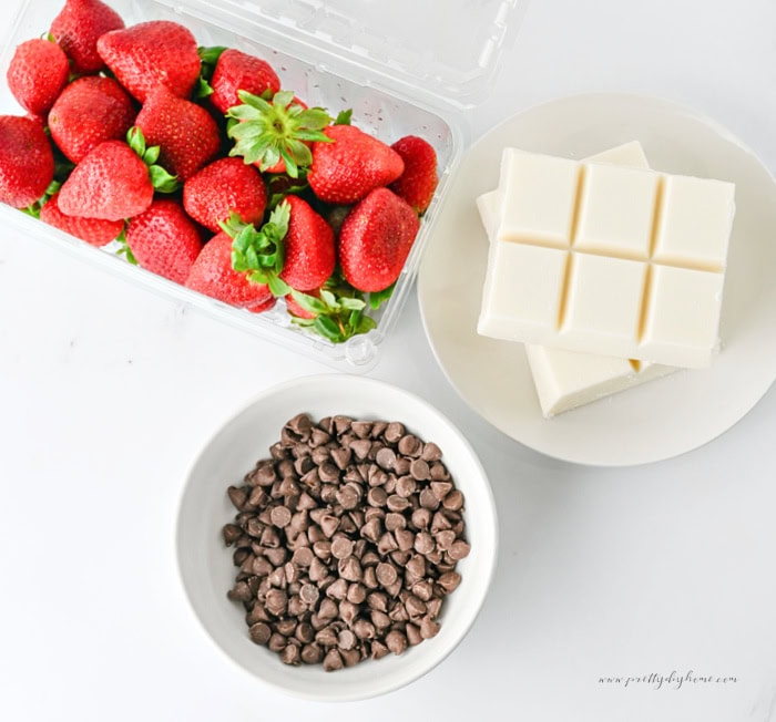 Fresh strawberries, vanilla almond bark, and chocolate chips for making strawberry ghosts